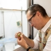 Alexander Butcher examines the number of mealybugs on a sprouted potato to measure the efficacy of mating disruption  Credit: Josie Noteboom